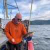 Mann som holder fangst ombord på fiskebåt